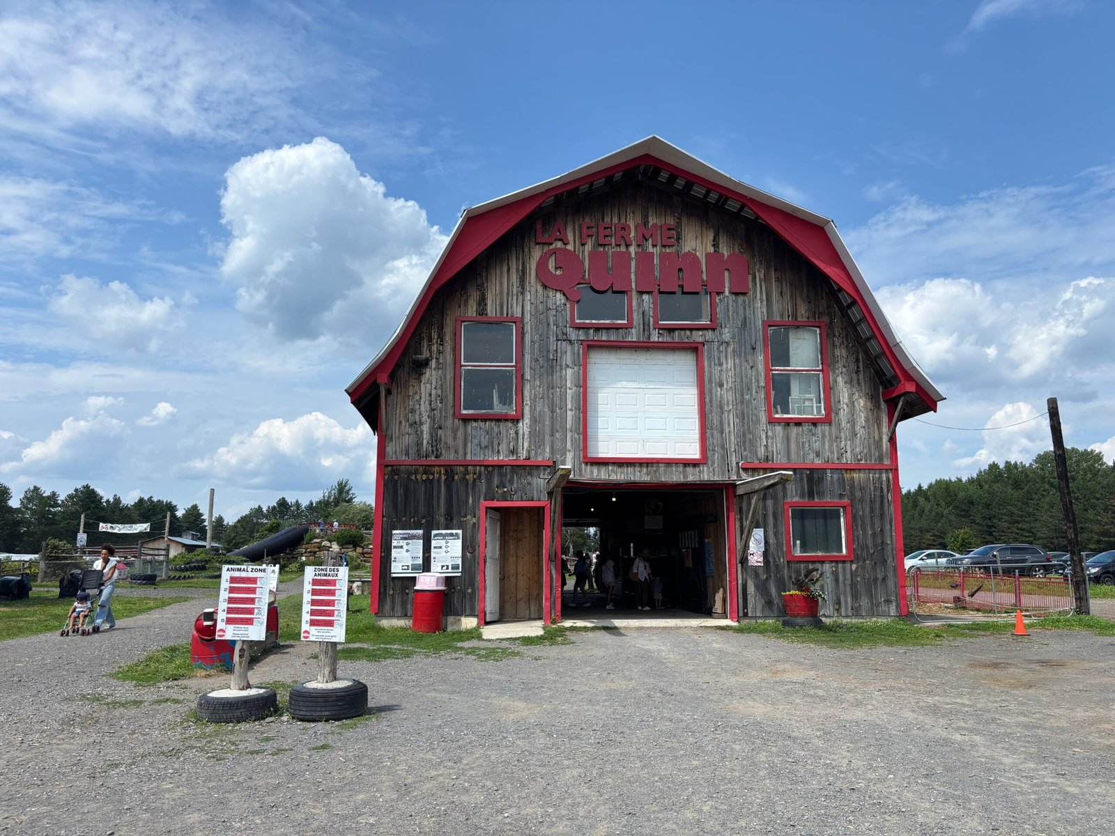 Quinn Farm barn entrance with signage and gravel pathway under a sunny sky.