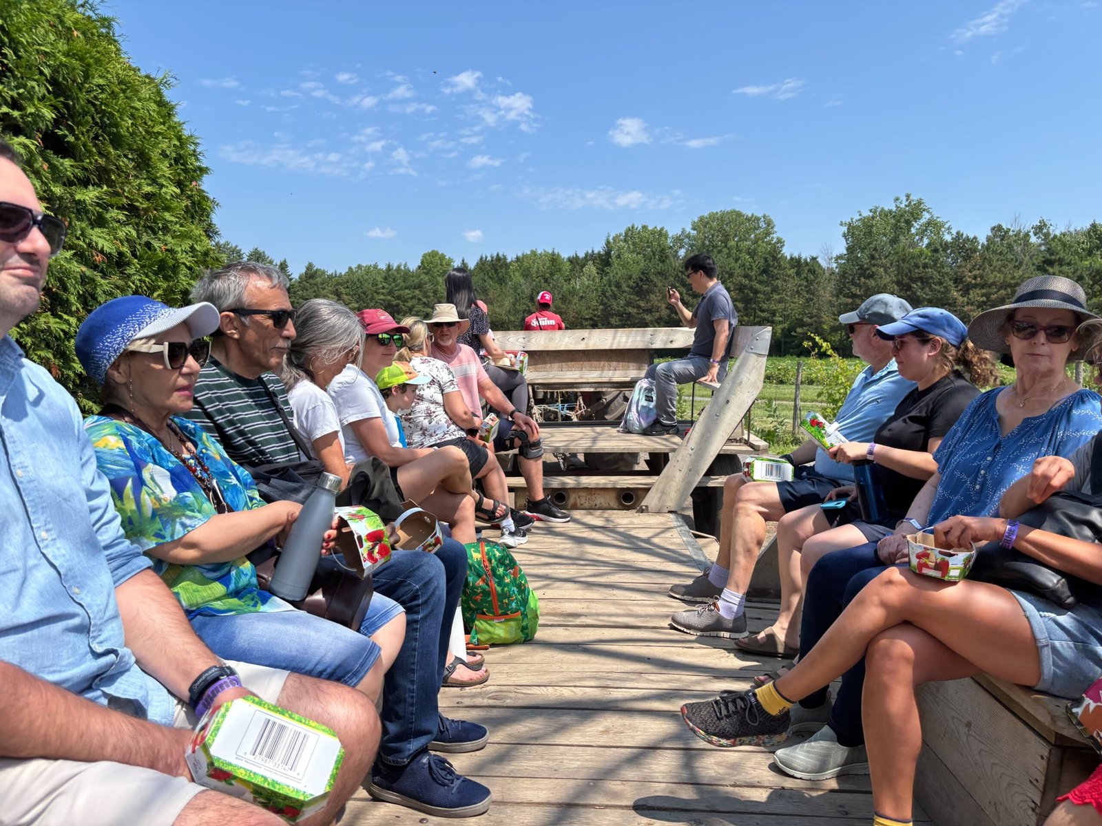 People sitting on wooden benches during a tractor-pulled wagon ride at Quinn Farm.