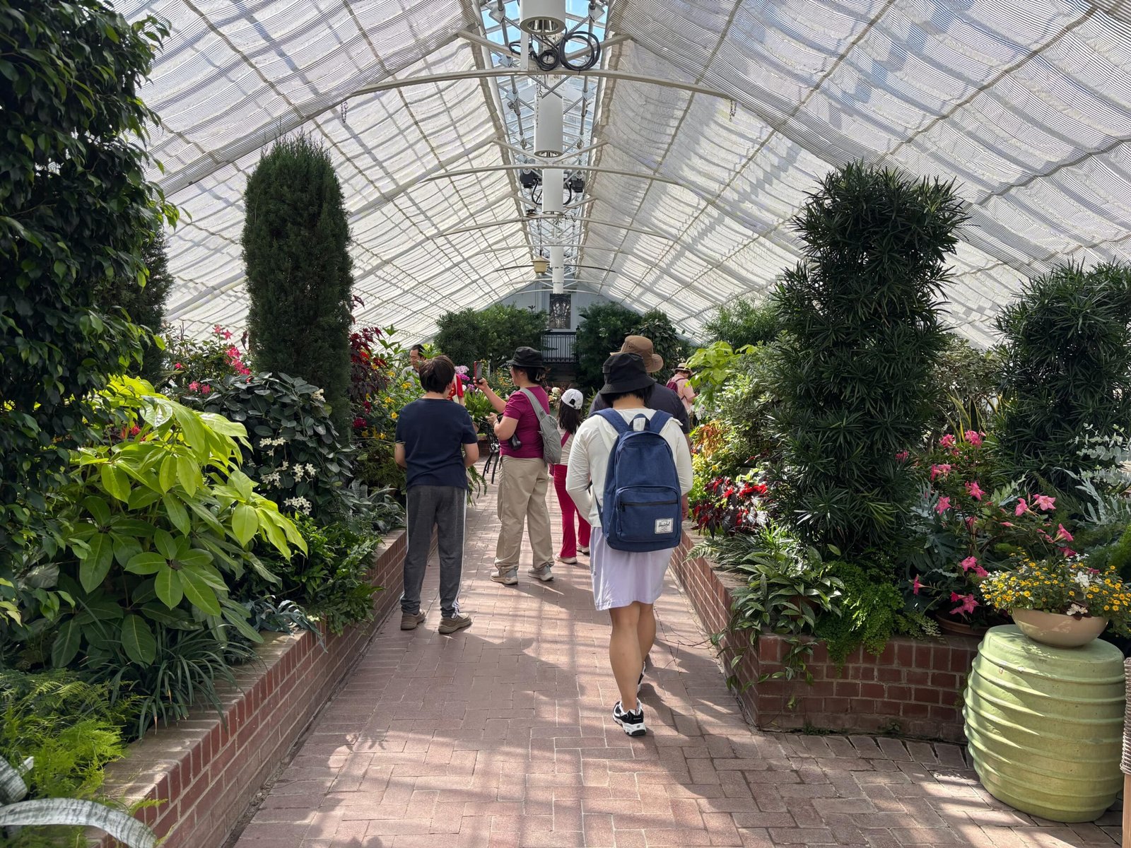 Visitors walking through the greenhouse at Rideau Hall filled with plants and flowers