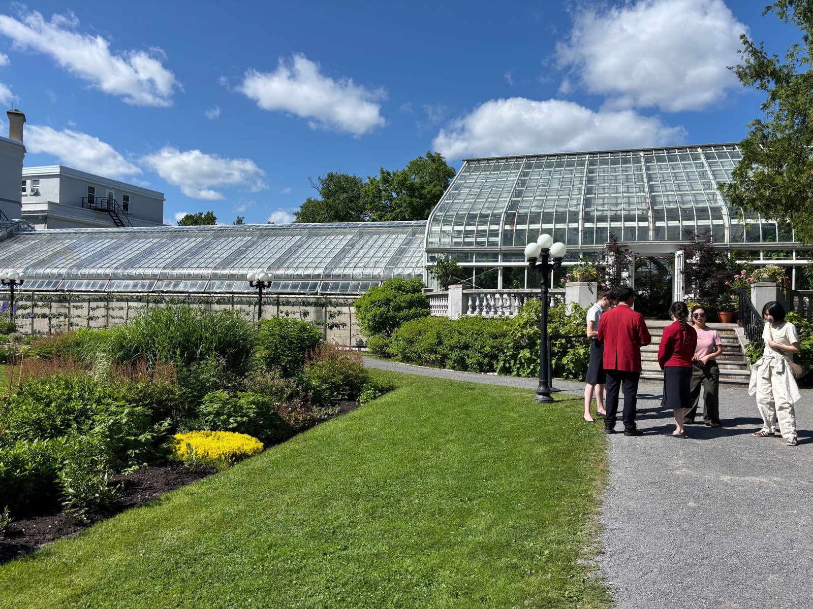 Exterior view of the greenhouse at Rideau Hall with visitors on the path