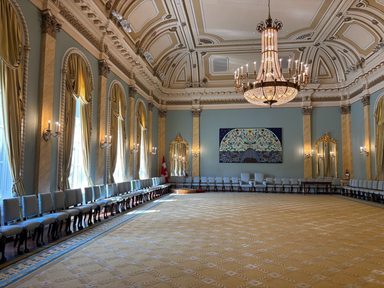 Ornate ceremonial hall at Rideau Hall with chandeliers, mirrors, and gold curtains