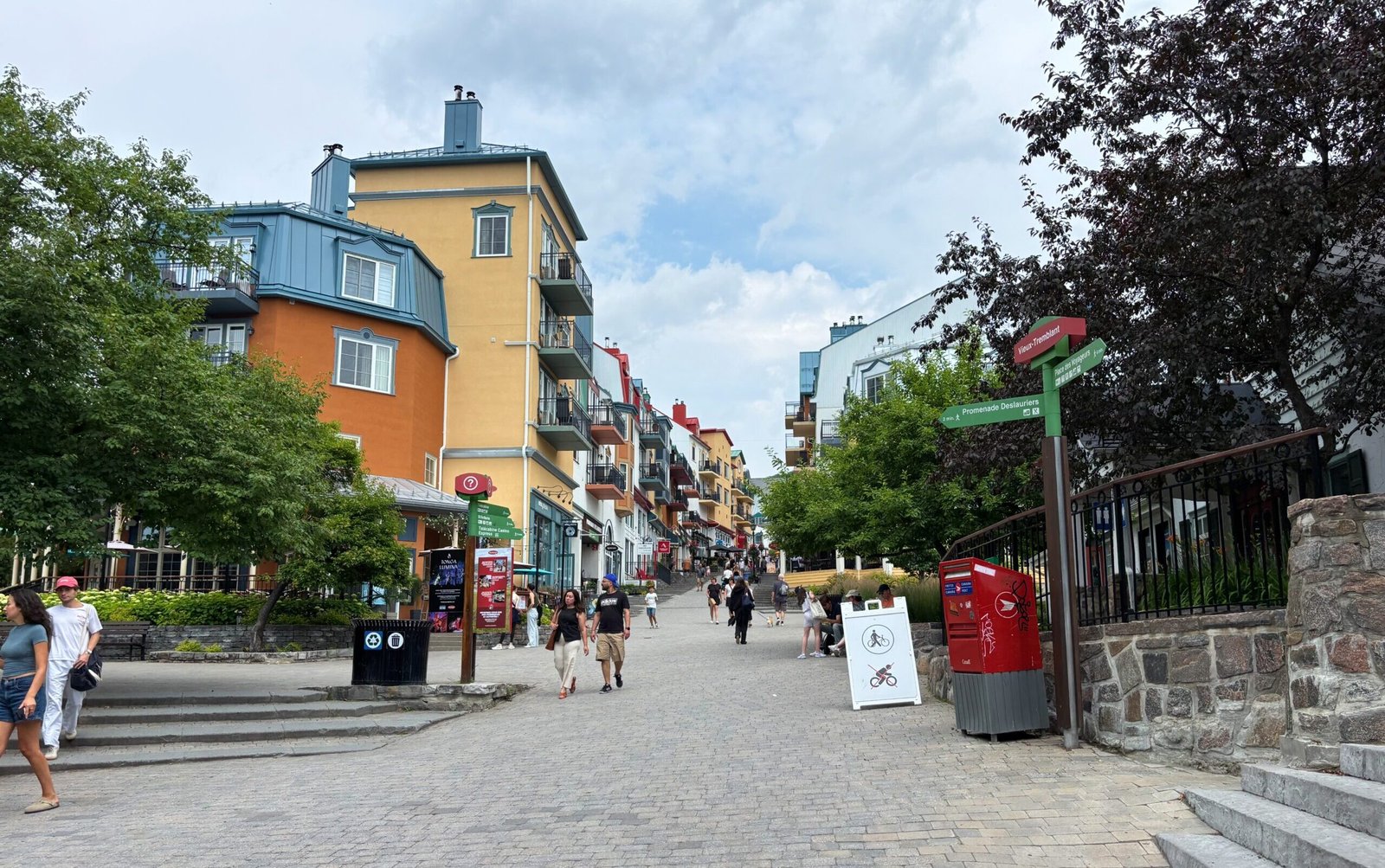 Mont-Tremblant pedestrian village with colorful buildings and people walking uphill