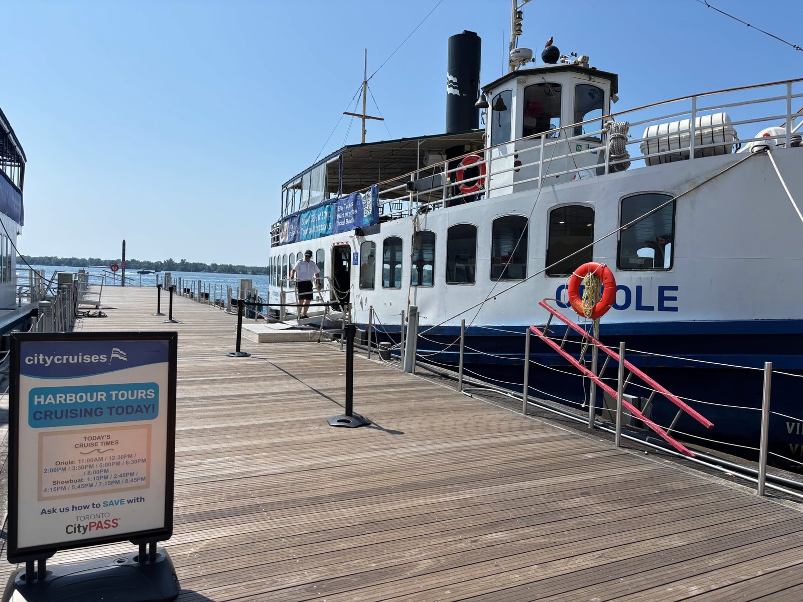 Oriole boat docked at Harbourfront with City Cruises sign and tour times.