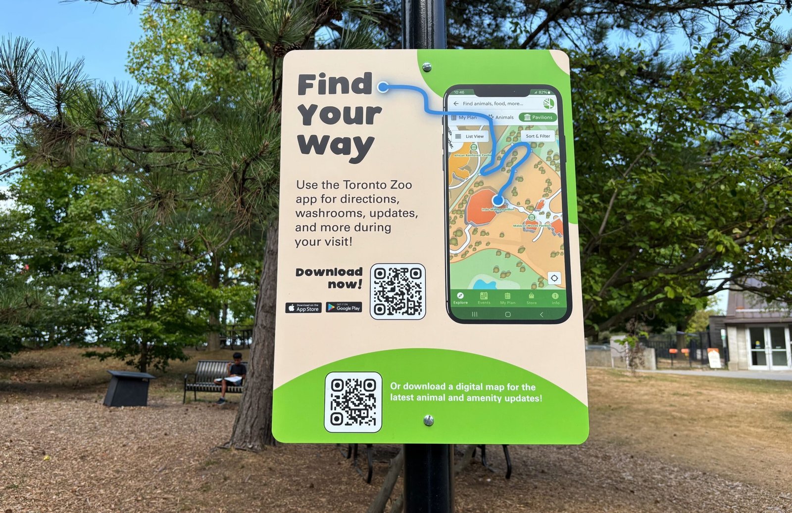 Directional sign encouraging visitors to download the Toronto Zoo app for maps and updates.