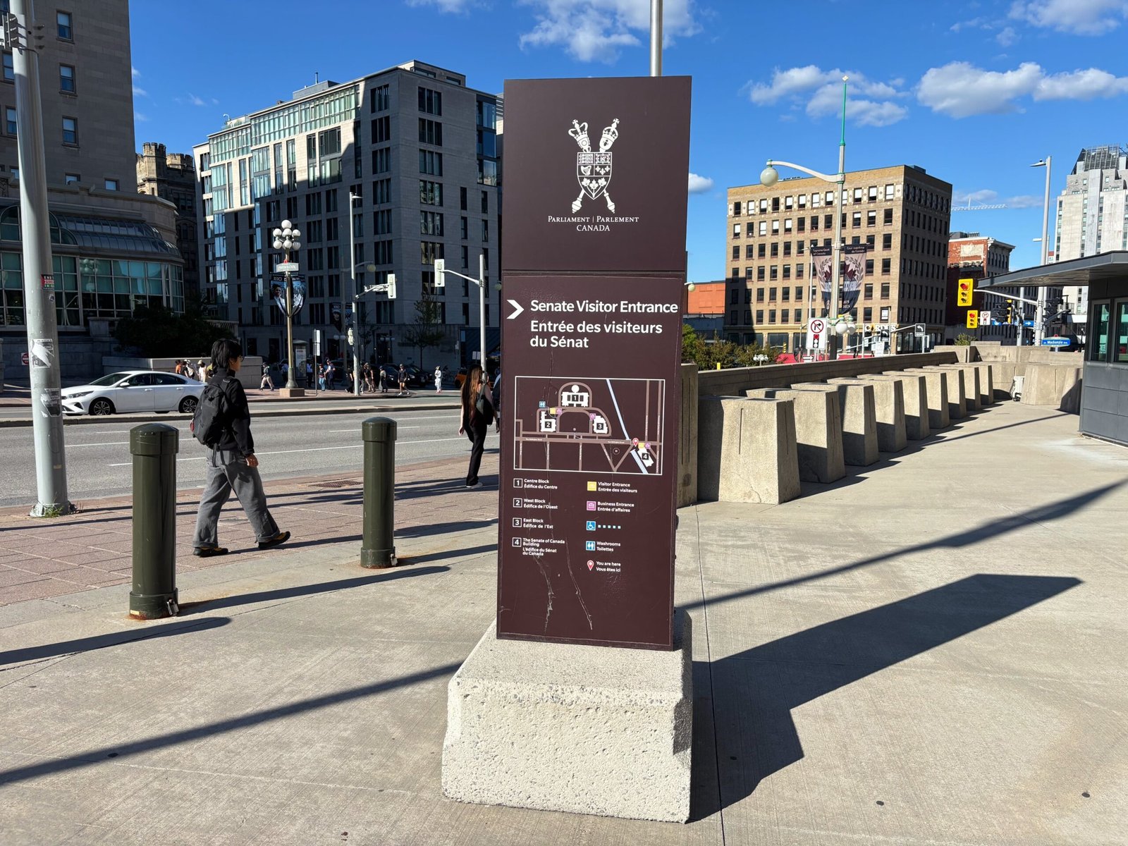 Outdoor Senate Visitor Entrance sign in Ottawa with map and directions.