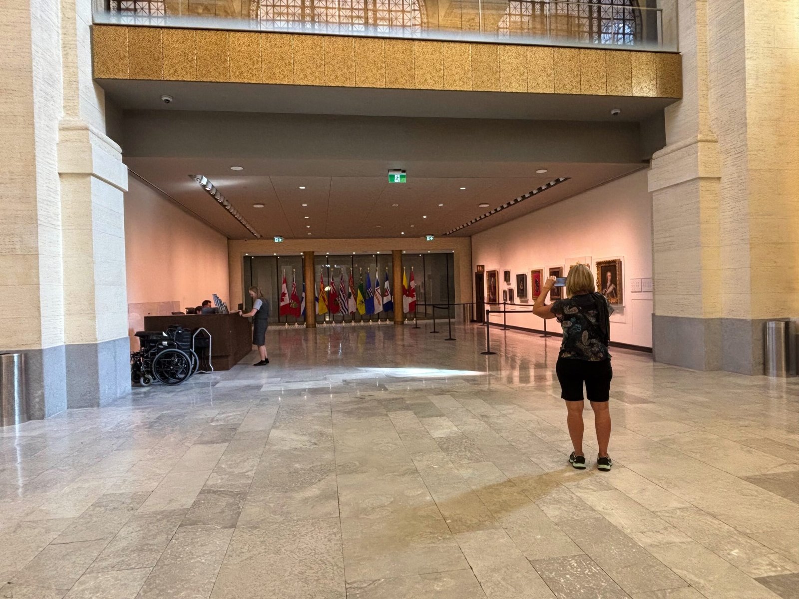 Entrance area of the Senate with reception desk, Canadian provincial and territorial flags in the background.