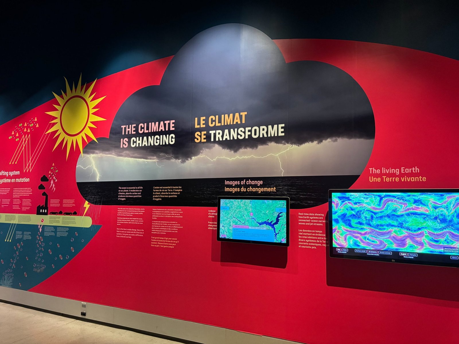 Exhibit wall about climate change with storm imagery and data screens