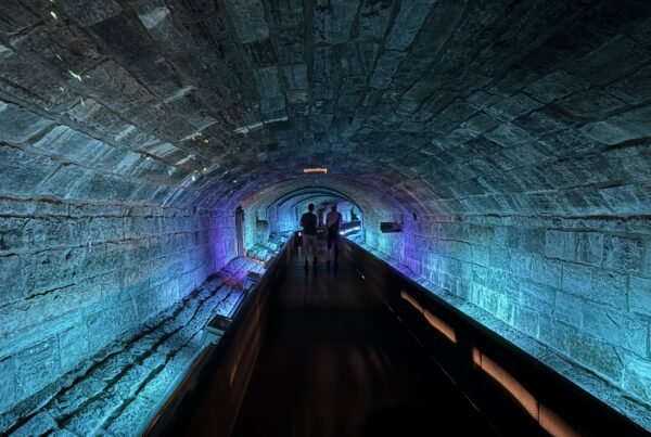 Colorfully lit stone tunnel that was once part of Montreal’s first sewer system, now open to visitors.