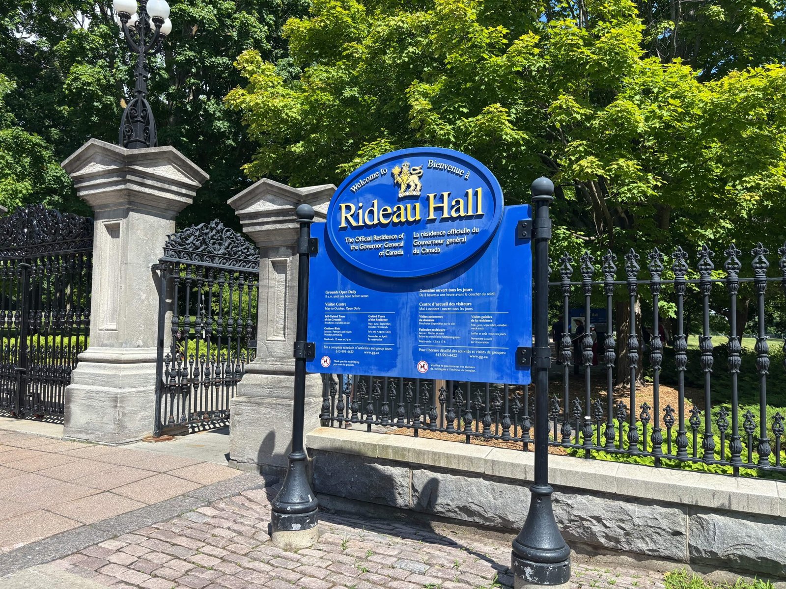 Ottawa's Rideau Hall entrance sign and ornate iron gate surrounded by trees