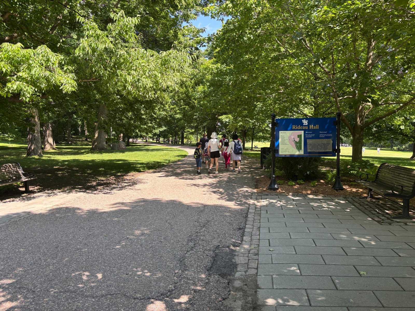 Visitors walking along a shaded pathway near Rideau Hall grounds