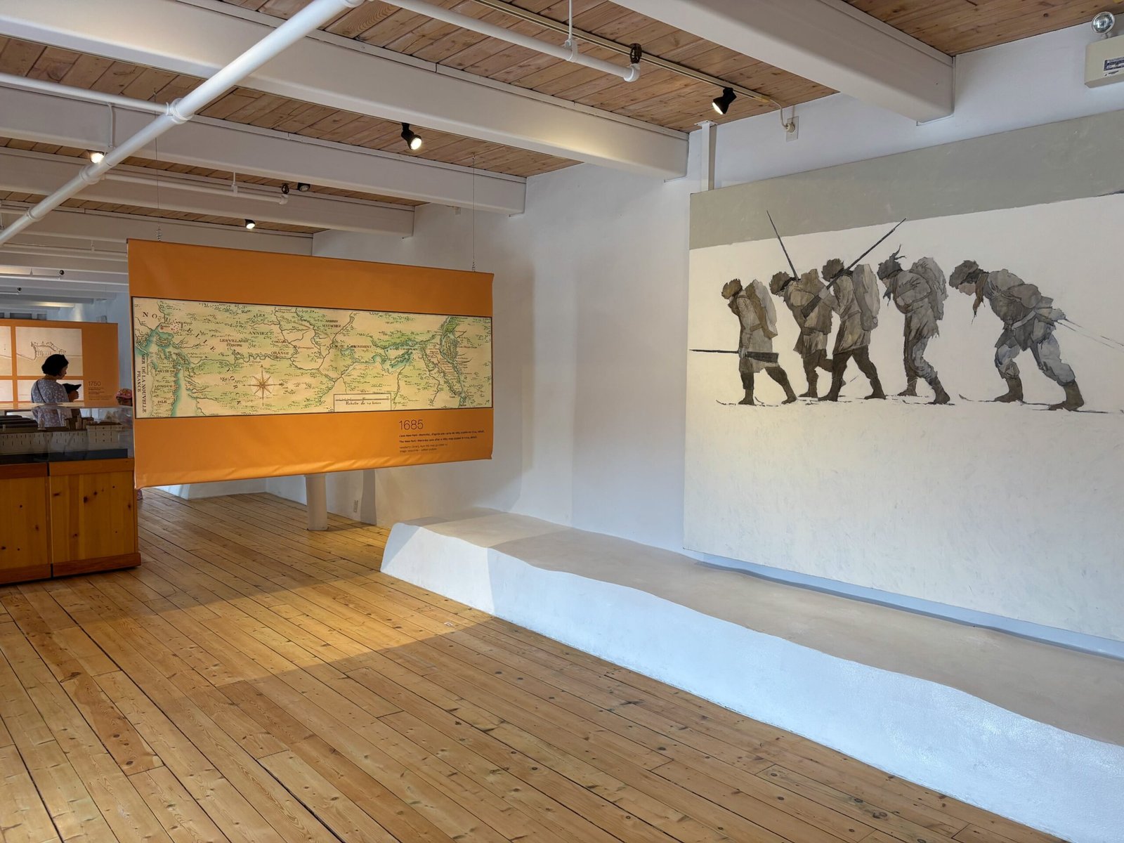 Historic map of New France and mural of soldiers at Fort de Chambly museum exhibit, Quebec.
