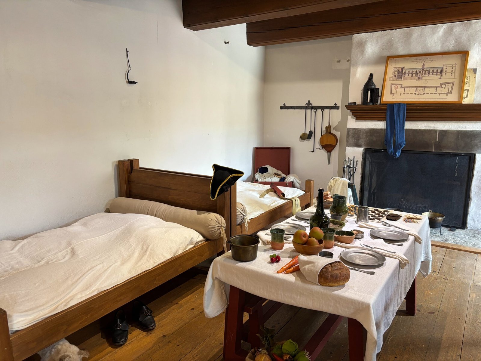 Recreated 17th-century soldiers’ quarters with beds, dining table, and fireplace at Fort de Chambly.