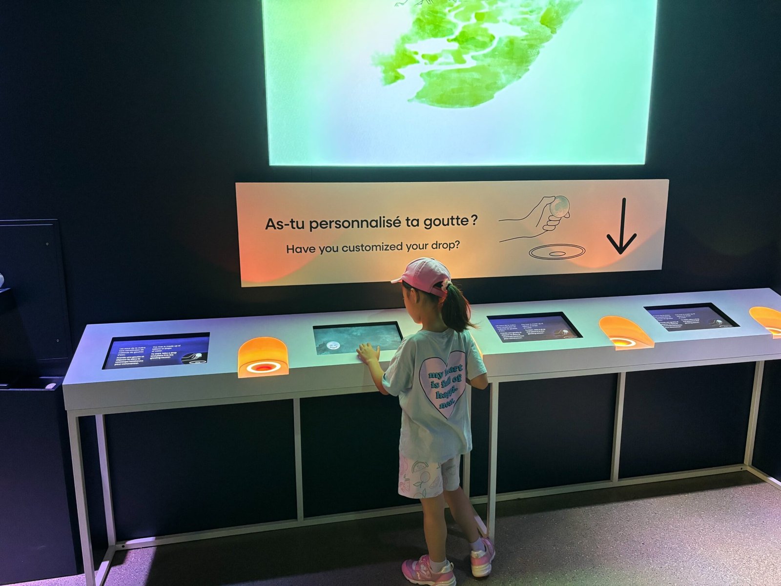 Child using interactive water-themed exhibit at the Biosphere Environment Museum in Montreal.