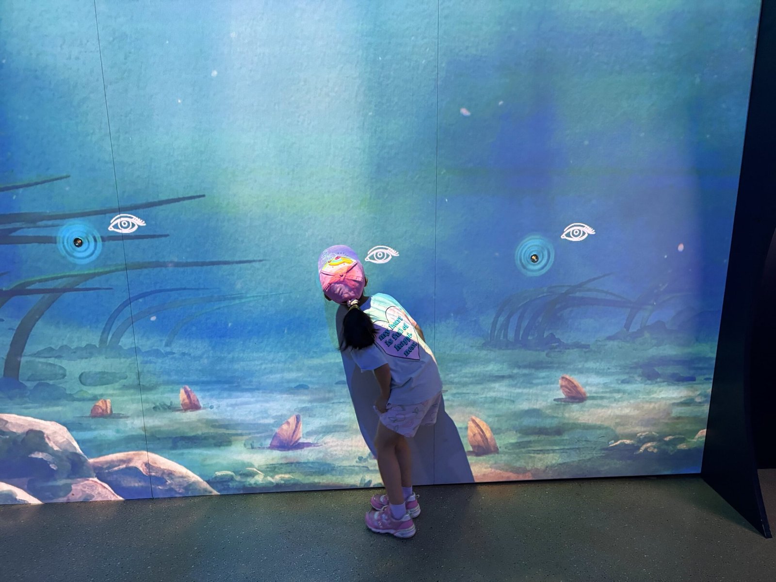 Young visitor exploring animated underwater digital wall at the Biosphere in Montreal.