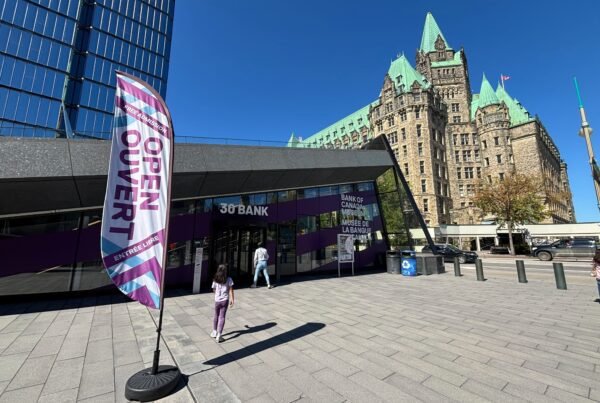 Exterior entrance of the Bank of Canada Museum with “Open / Ouvert” flag at 30 Bank Street, Ottawa.