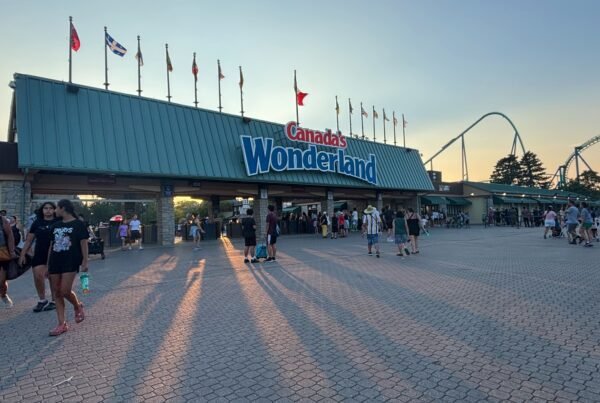 Evening view of Canada’s Wonderland entrance with visitors leaving at sunset.