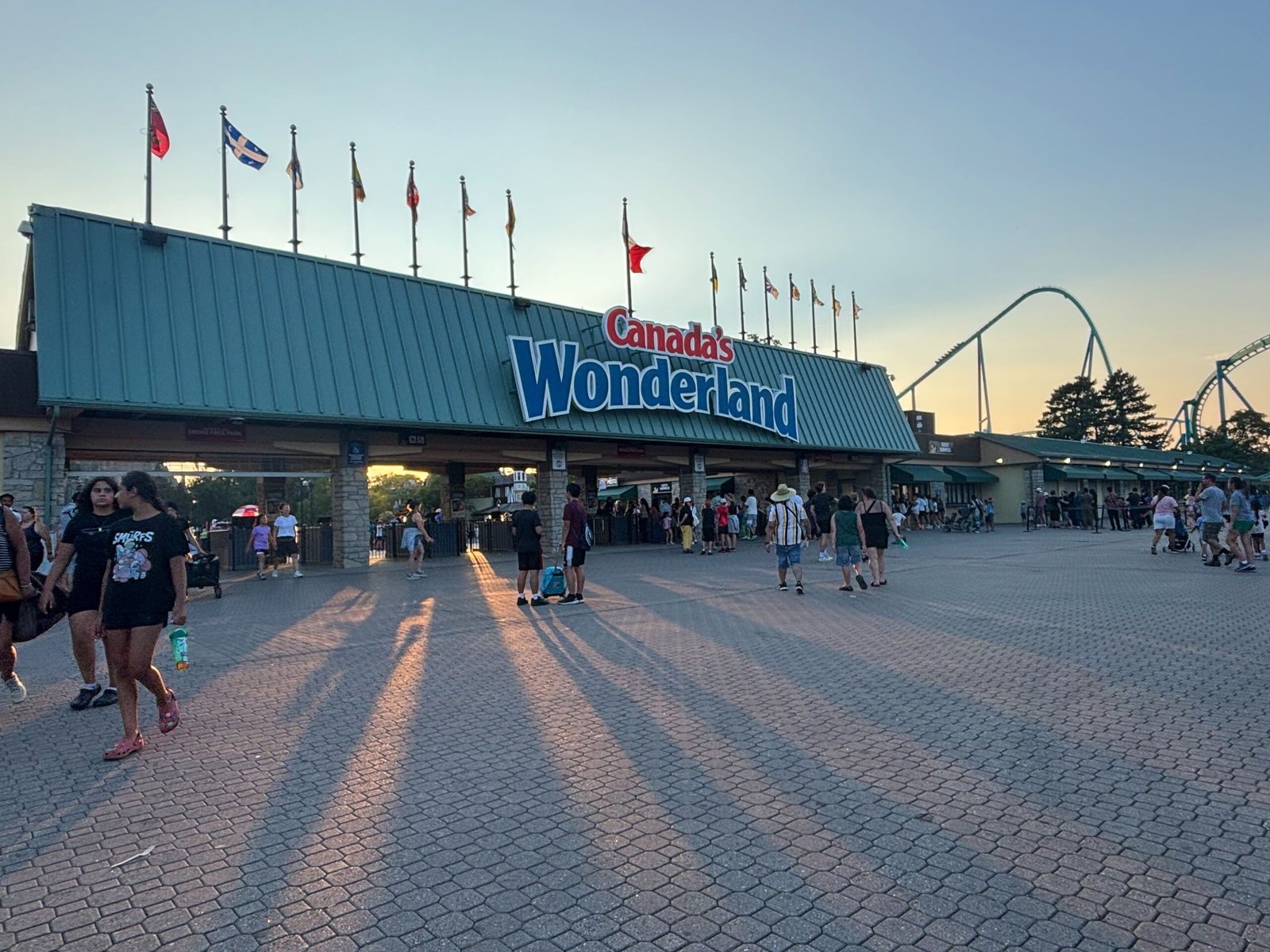 Evening view of Canada’s Wonderland entrance with visitors leaving at sunset.