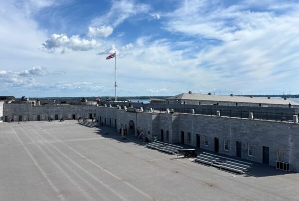 Wide view of Fort Henry’s courtyard with Union Jack flag flying above the ramparts.