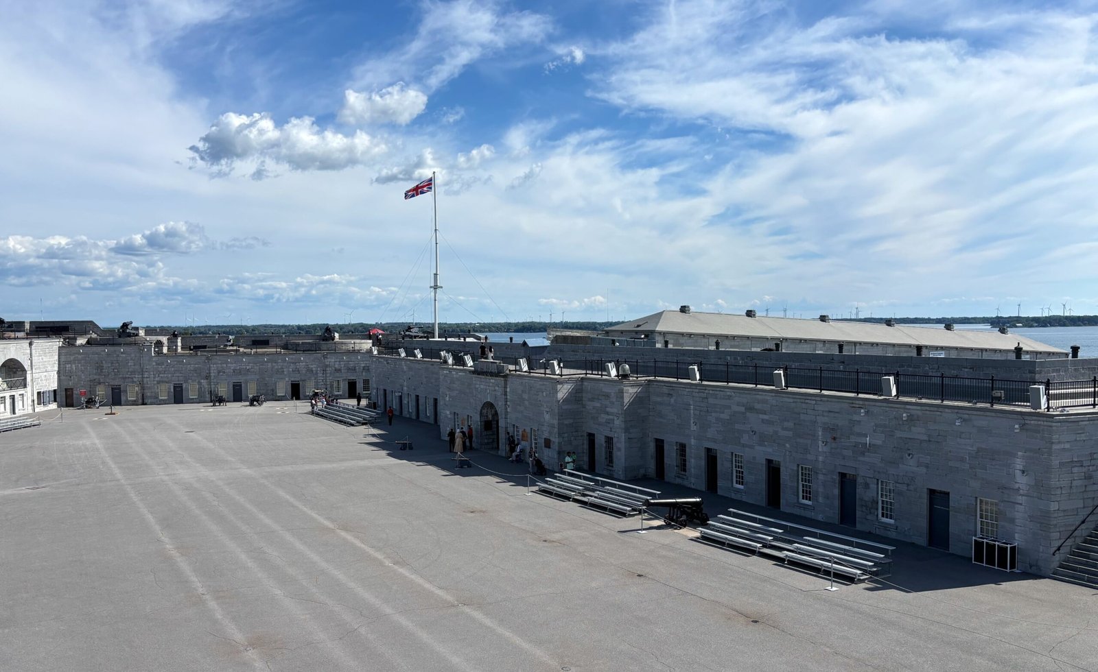 Wide view of Fort Henry’s courtyard with Union Jack flag flying above the ramparts.