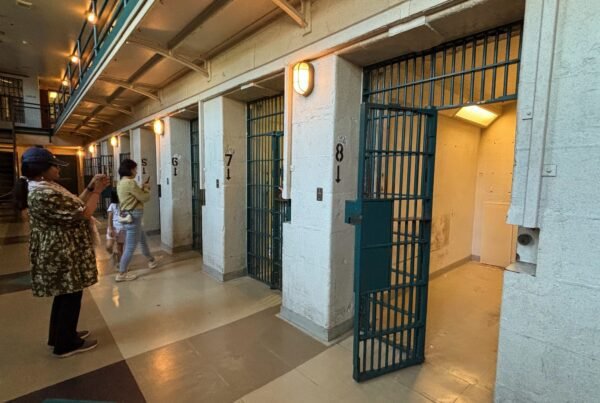 Row of numbered prison cells with doors open inside Kingston Penitentiary.