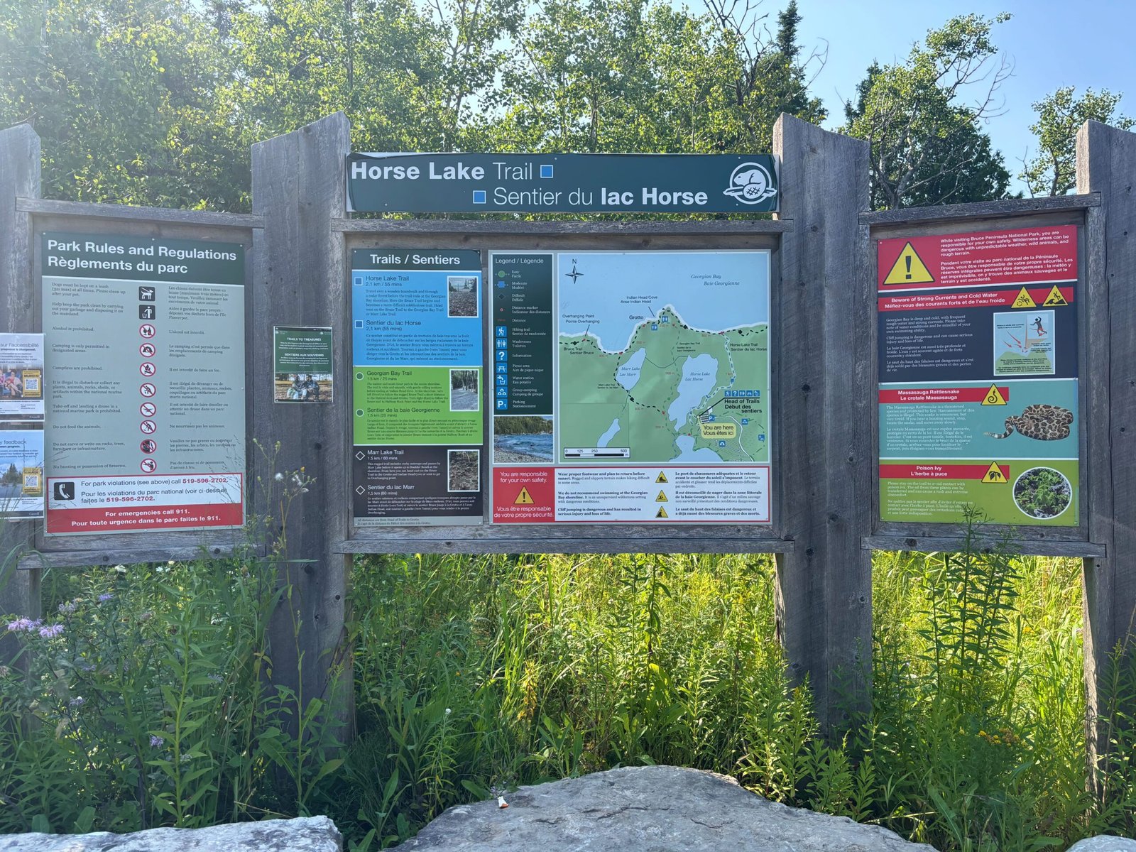 Information board at Horse Lake Trail in Bruce Peninsula National Park with maps, trail descriptions, and safety rules.