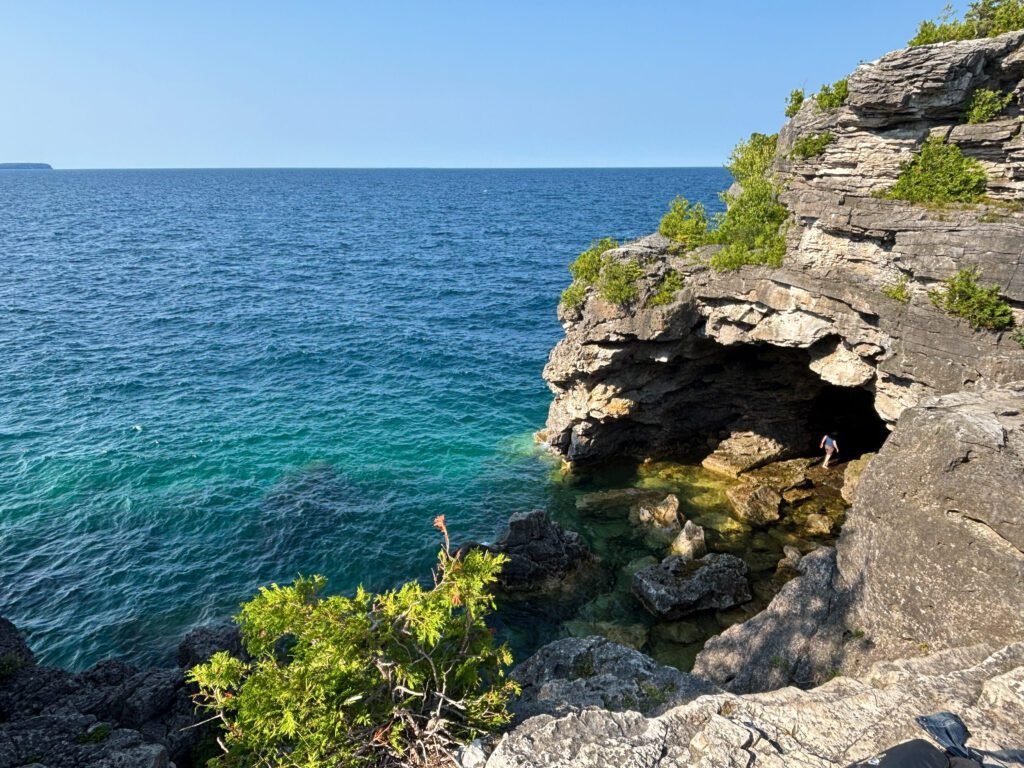 Rocky cave opening at the Grotto in Bruce Peninsula National Park, with turquoise water entering the cavern.